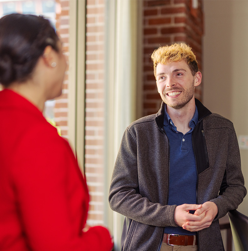 USF student smiling while chatting with someone in professional attire