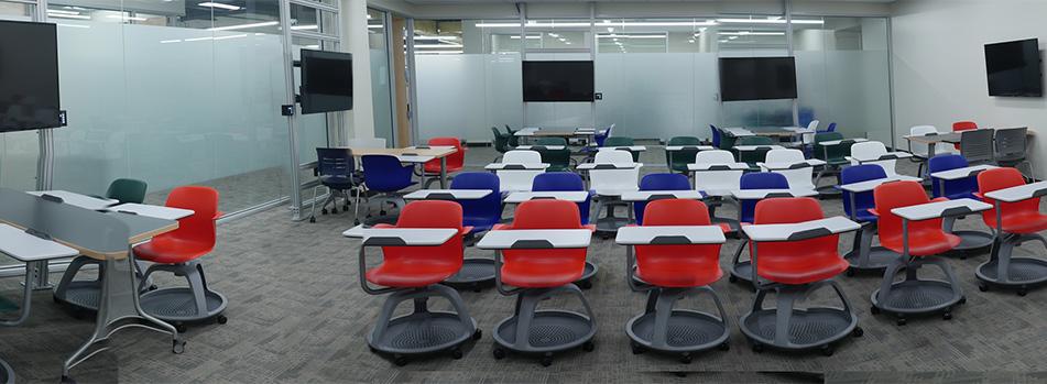 Gleeson 213 active learning classroom with colored rolling chairs and multiple screens