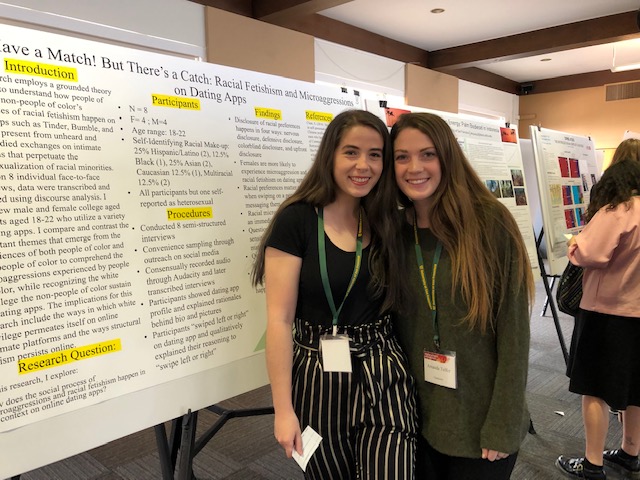 Two student researchers pose with their poster project. 