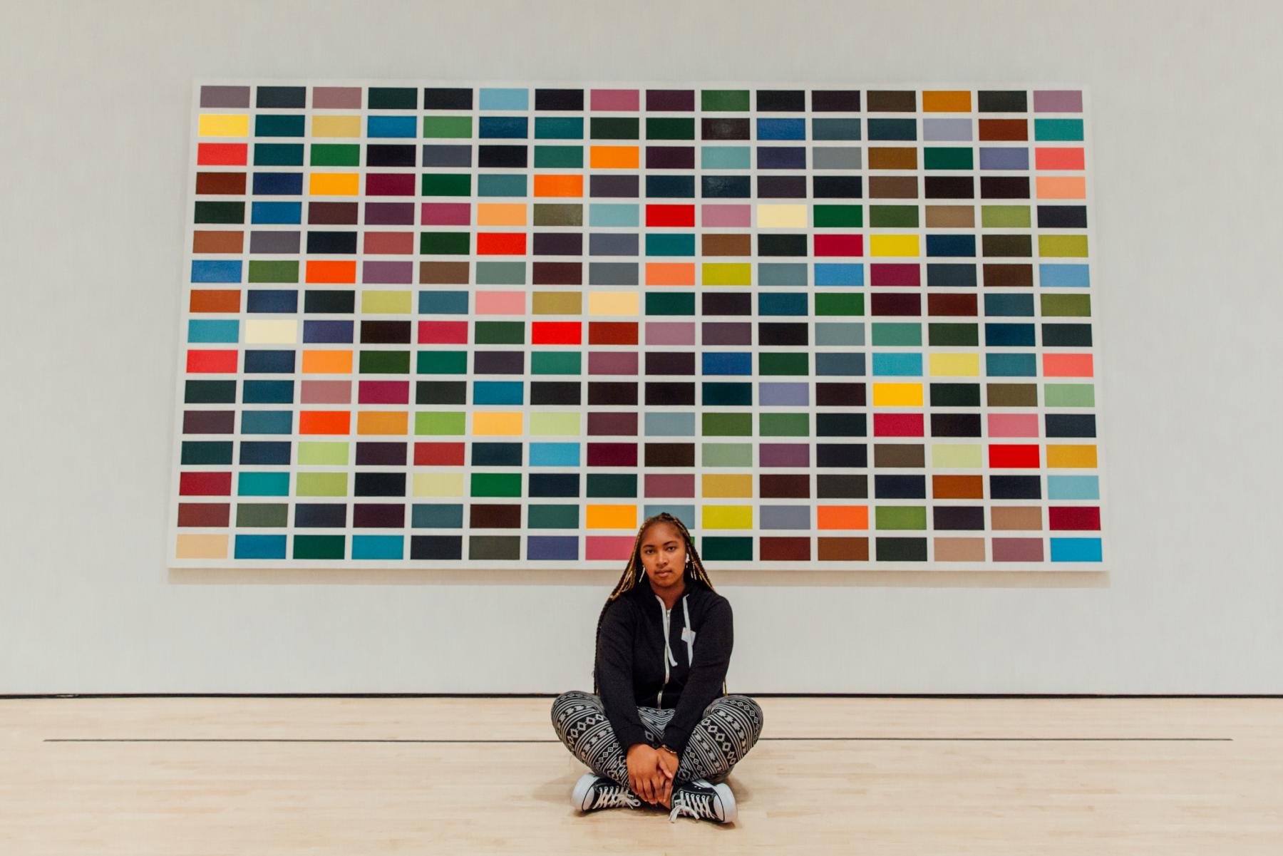 Student sits in front of painting at SF MoMA