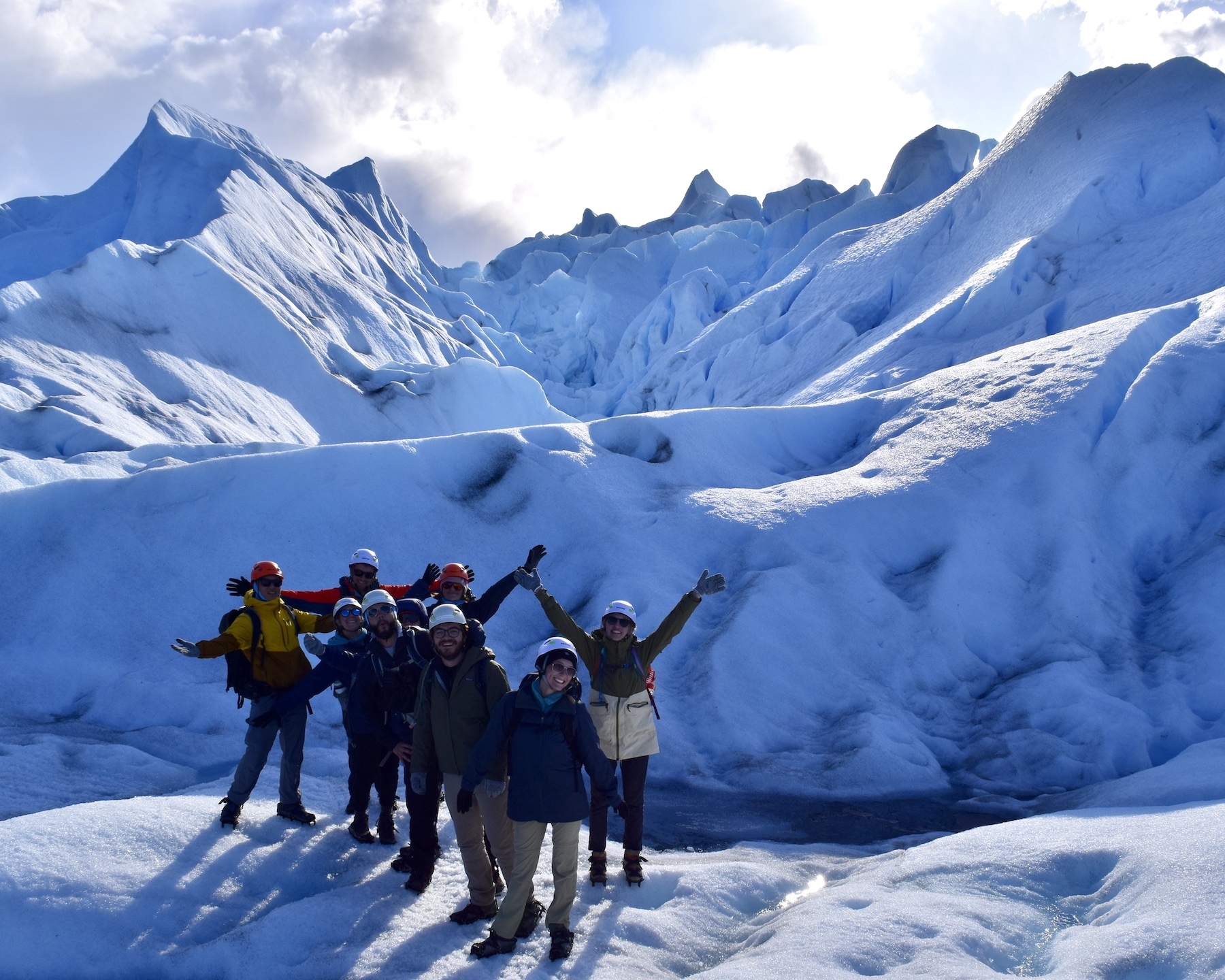 Photo of a group of students posing together in front of an ice cap.