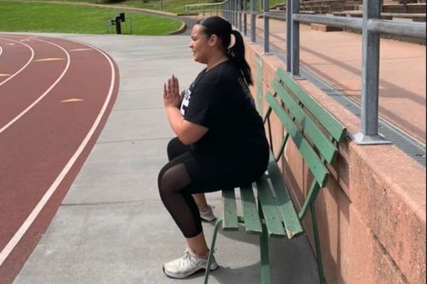 Trainer squatting on bench