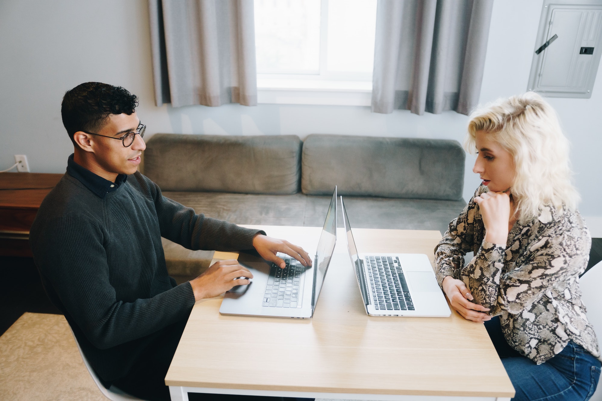 Two people working on laptops at a table