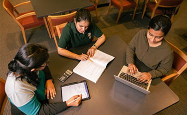 Three students working on homework together