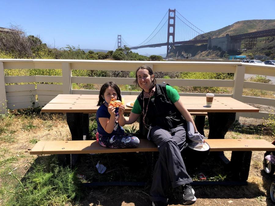 Kimberly and her daughter on a picnic table in front of Golden Gate Bridge