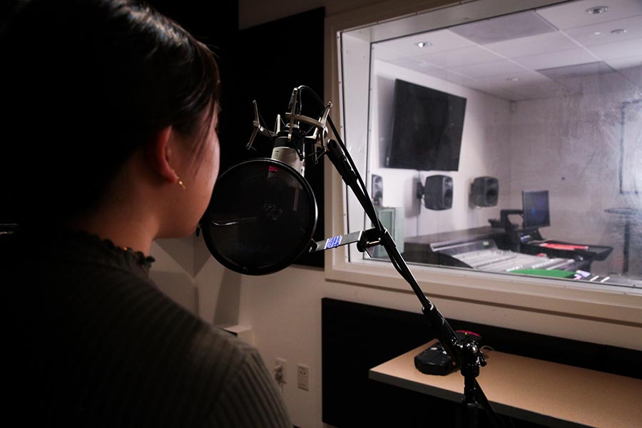 Student singing in a recording studio