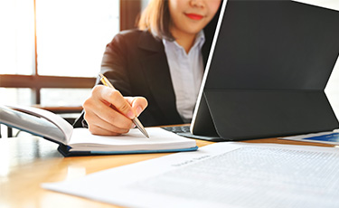 Business woman working with notebook and tablet on desk