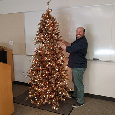 Scott Moules standing next to a christmas tree