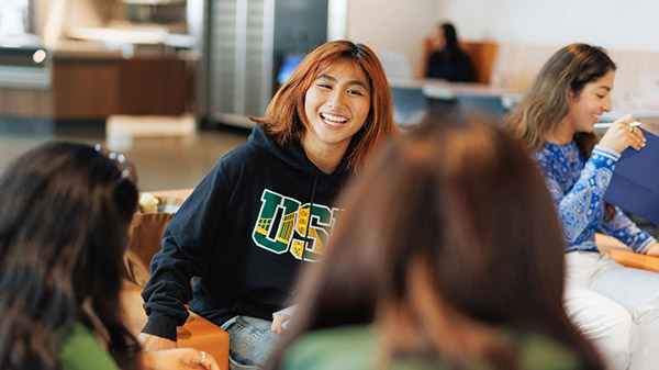 Student smiling and talking to other students