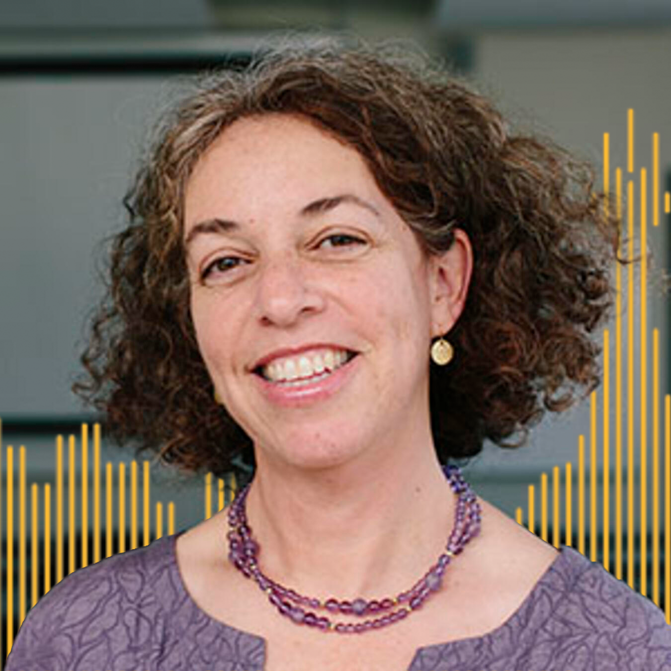 Headshot of Kelly L'Engle with yellow lined buildings in the background
