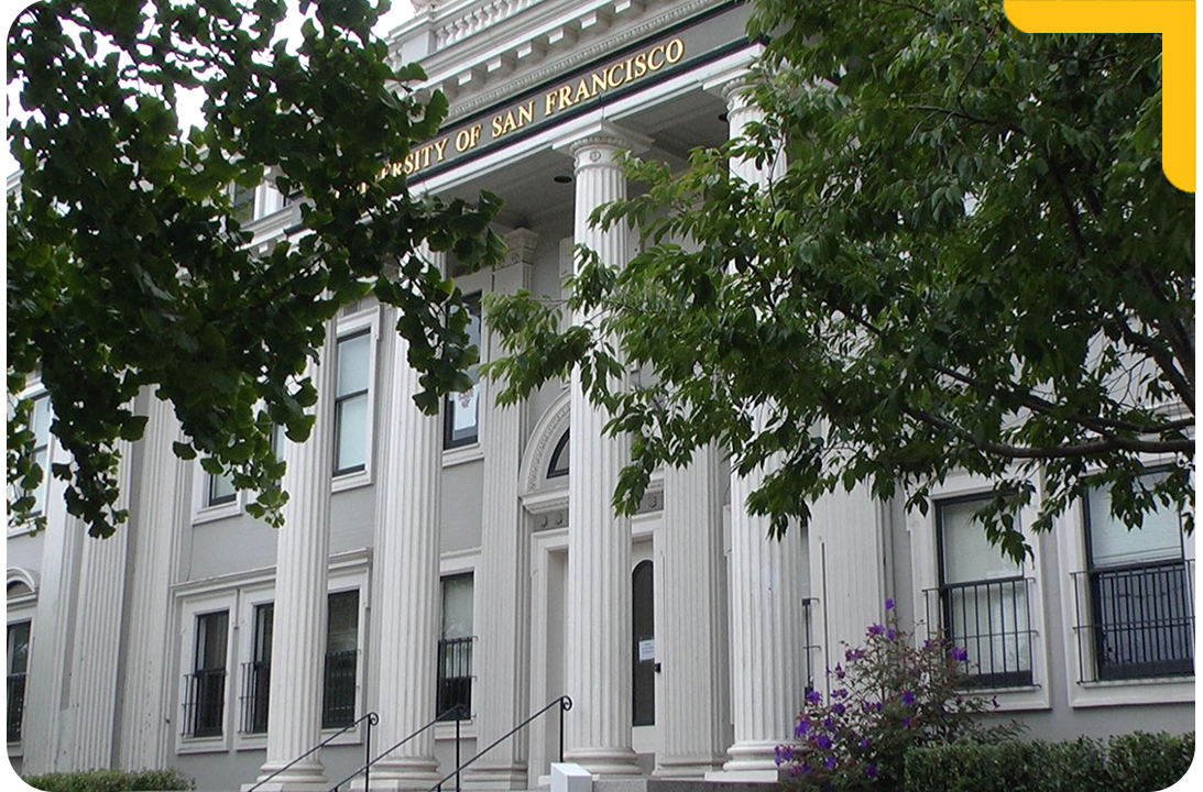"White University of San Francisco building surrounded by trees"