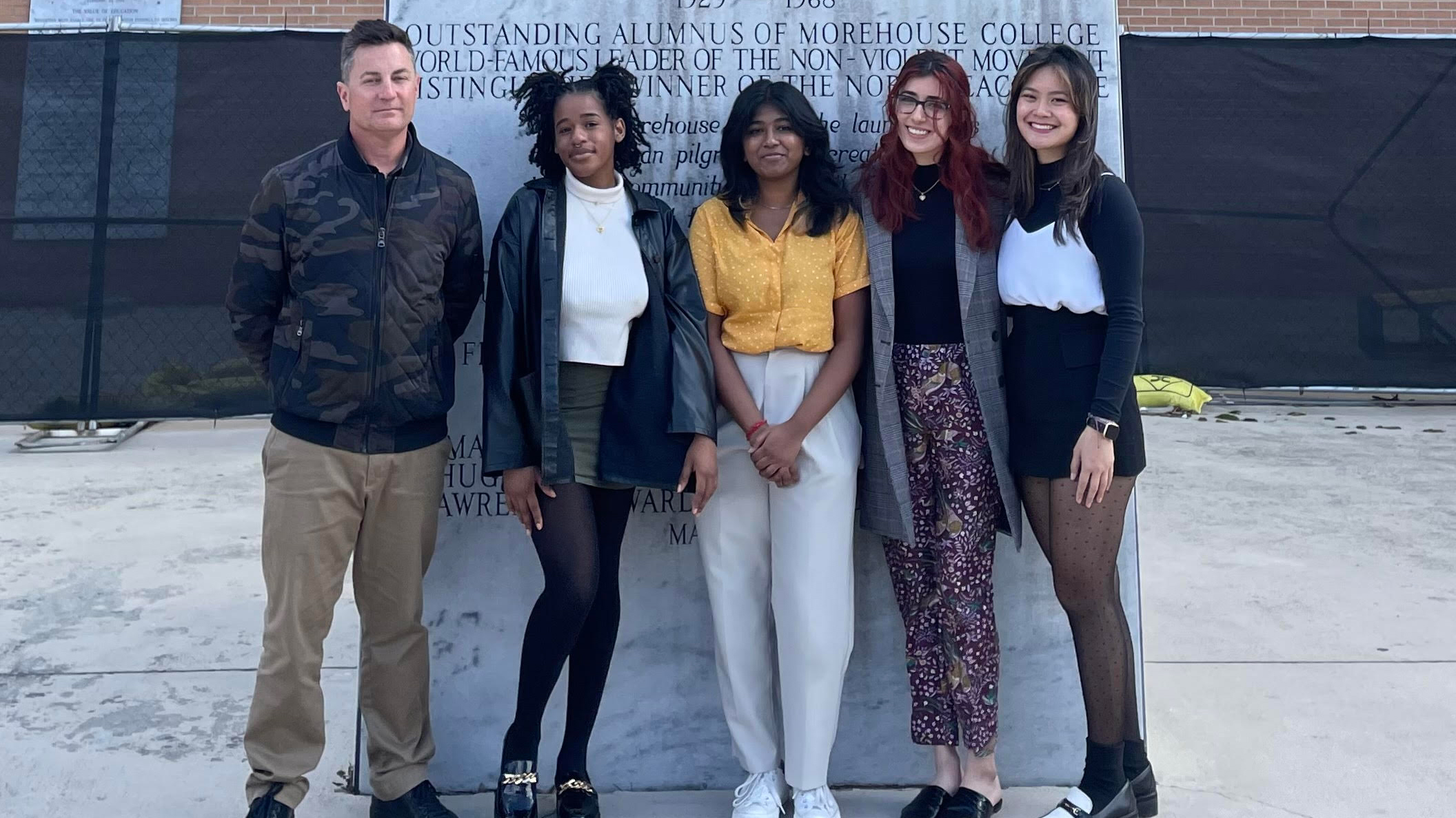 students standing in front of a memorial statue