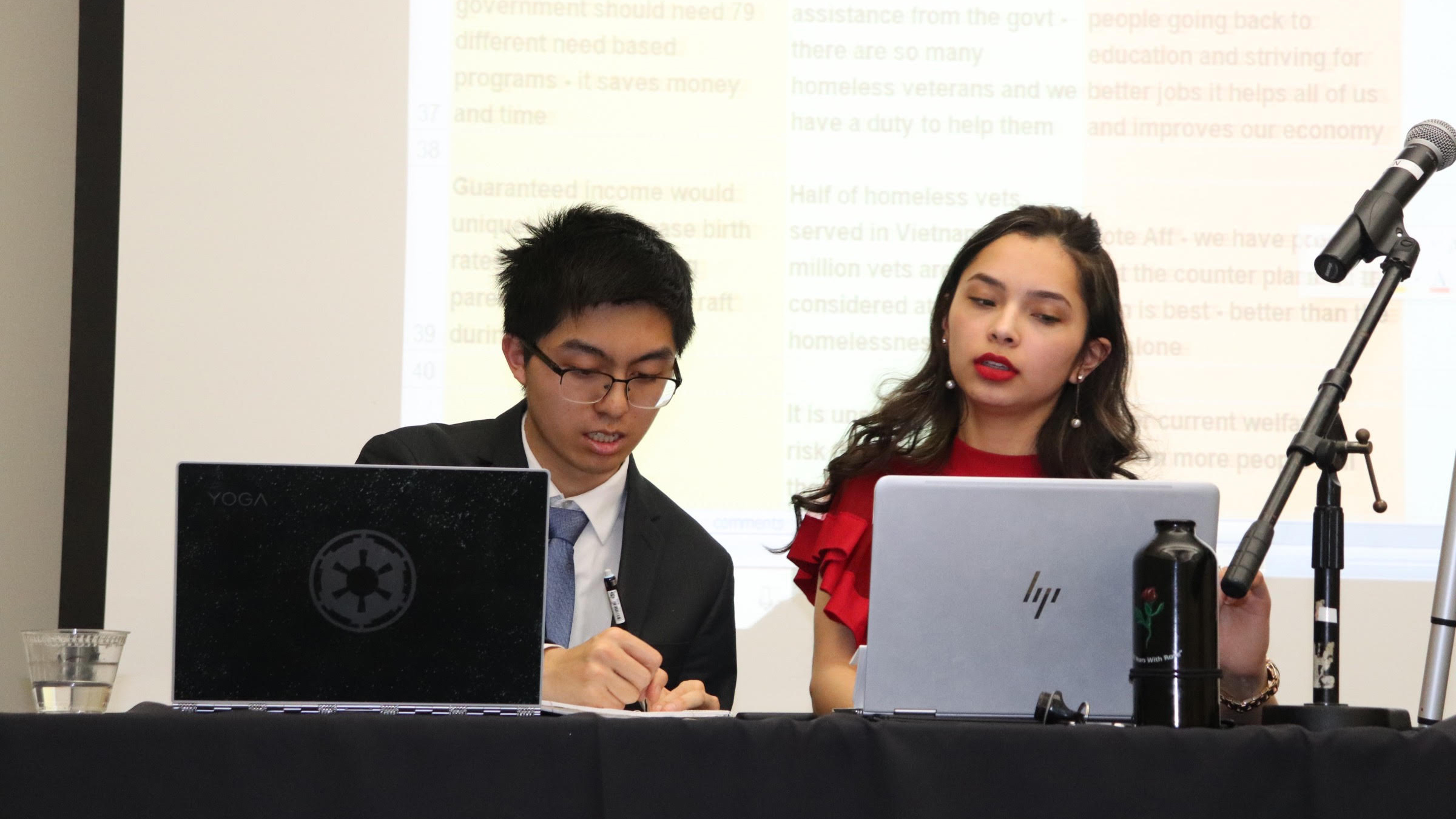 students speaking in front of laptops