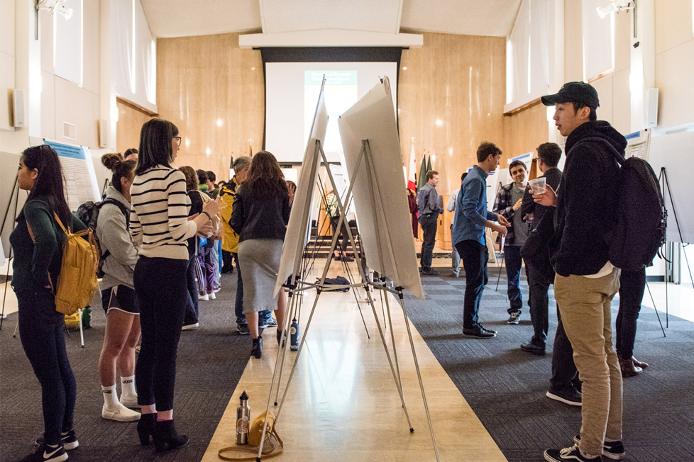 Students presenting research in large hall