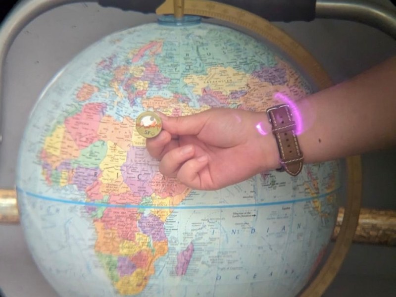 Wanda Quan '24 helping to calibrate a telescope using a lapel pin and globe.