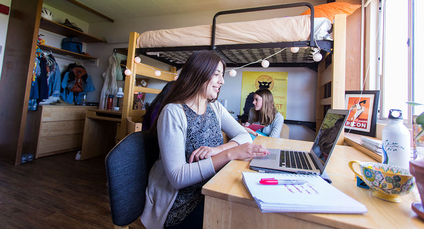 students sitting and talking in dorm room