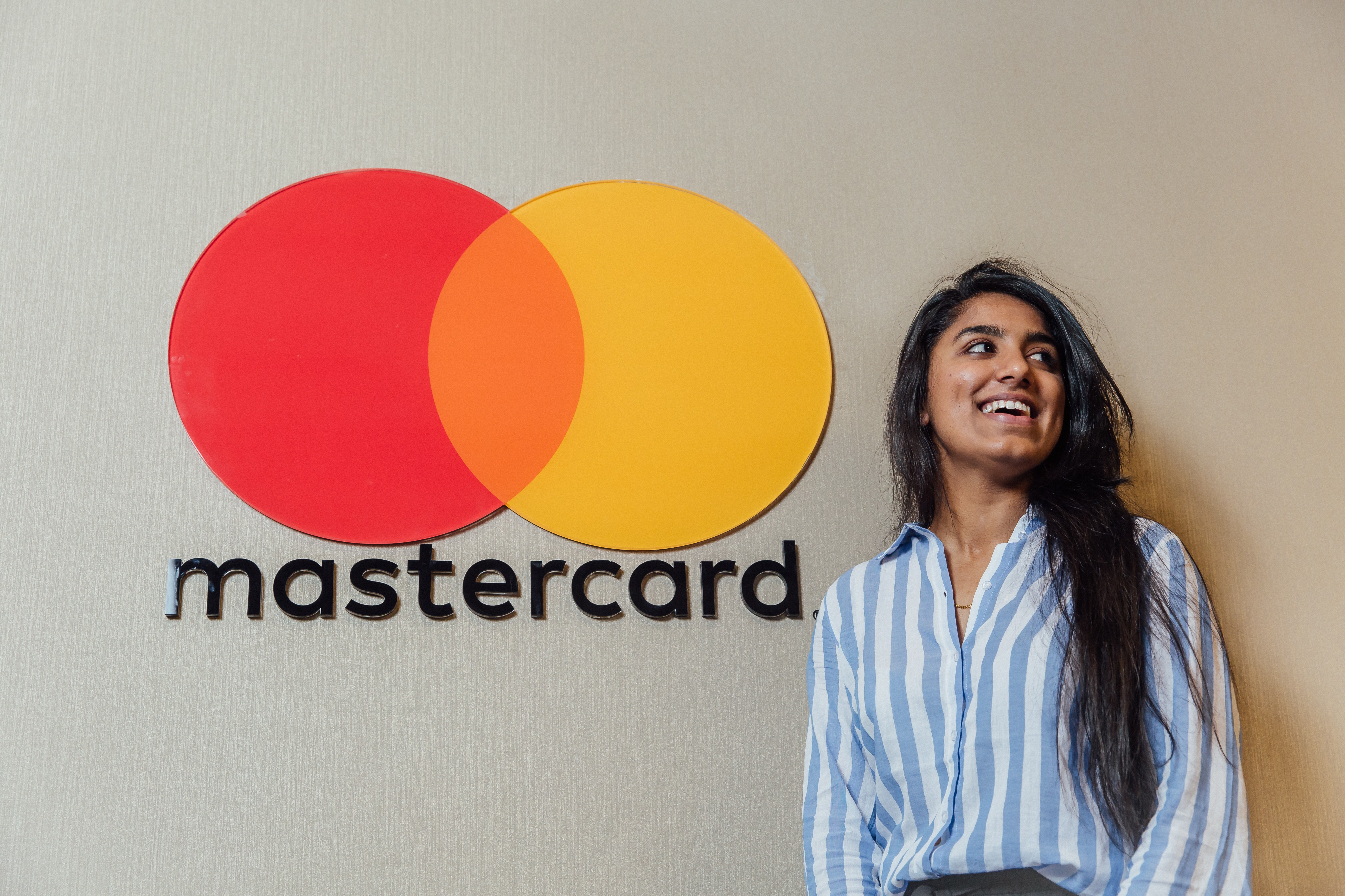 Student in front of the Mastercard company logo