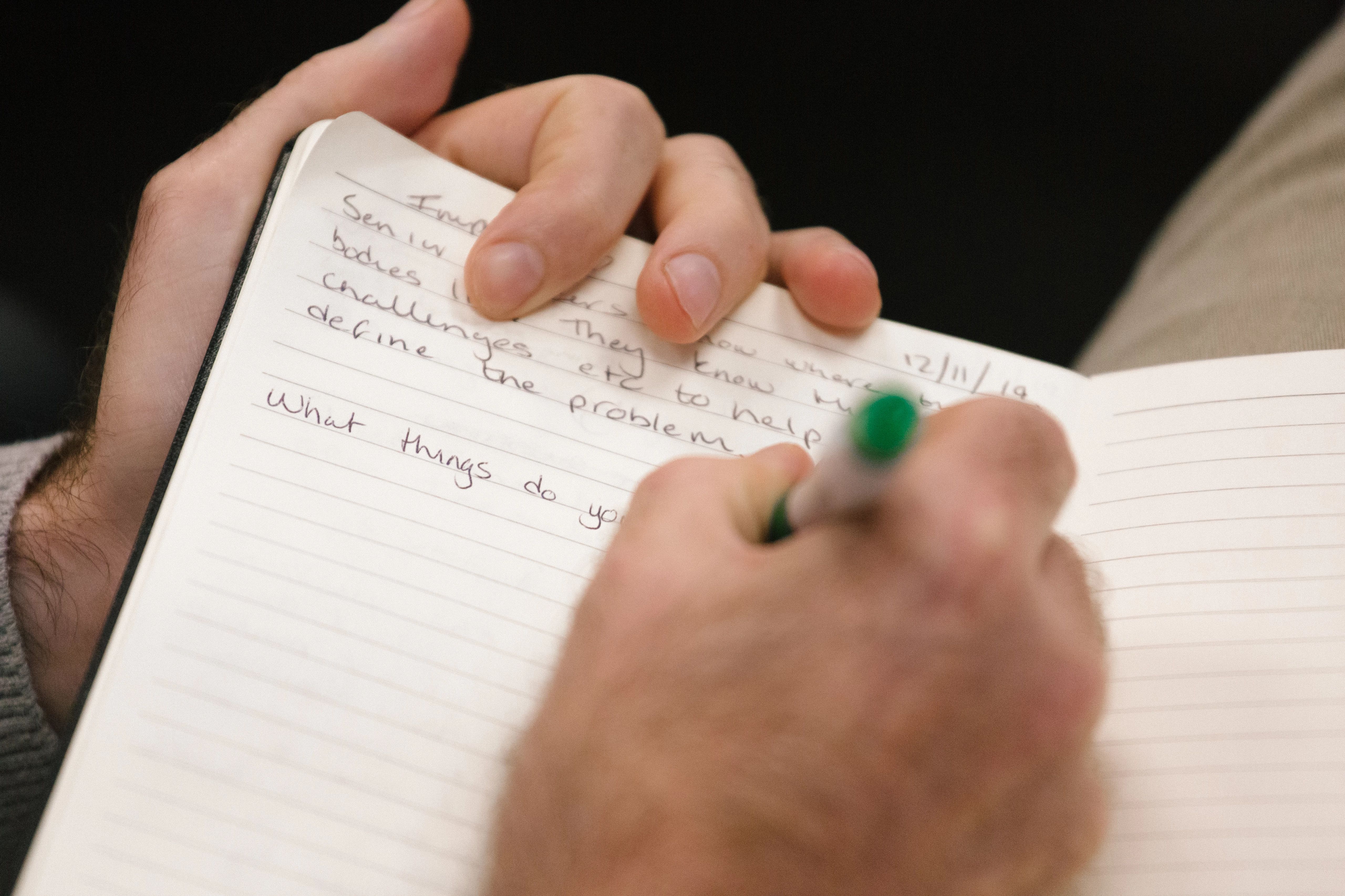 person writing in notebook