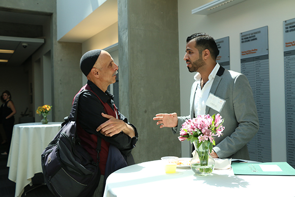 two men speaking to each other during event
