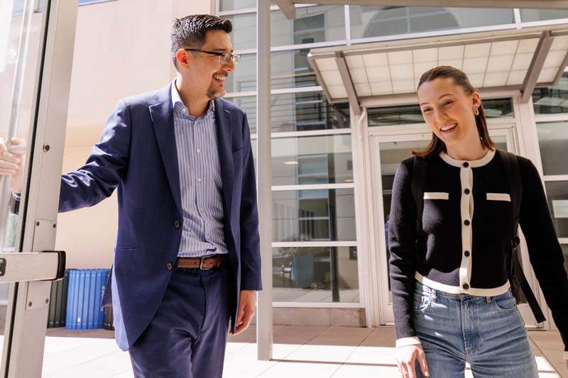 Faculty opening a door for a student