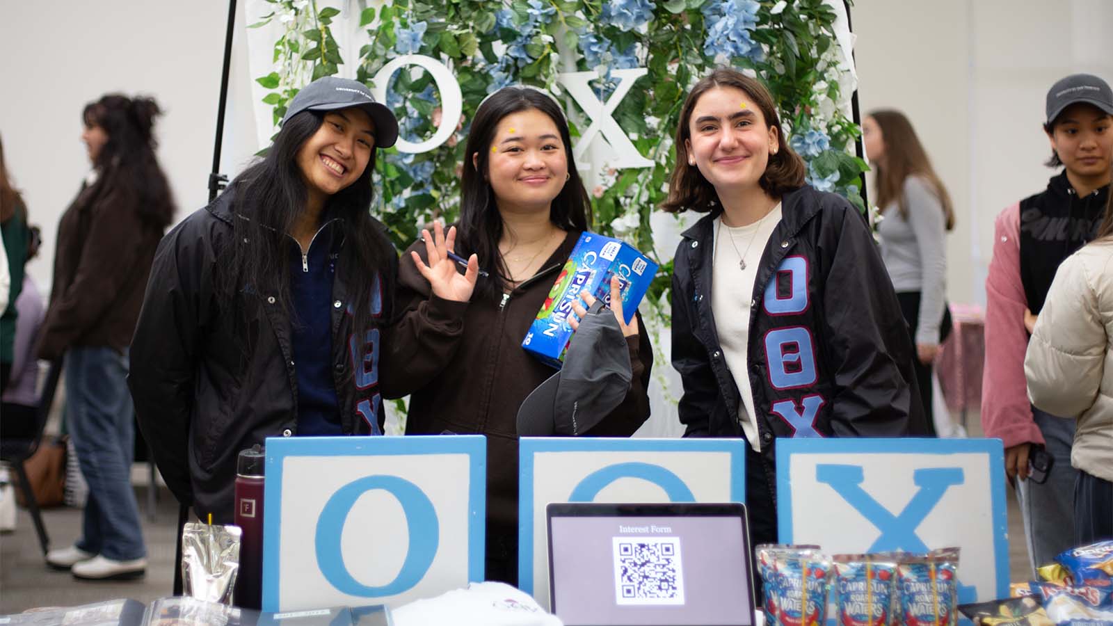 Students in front of a table with Greek letters