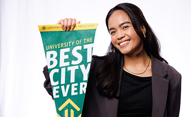 USF staff member smiling, holding "Best City Ever" banner