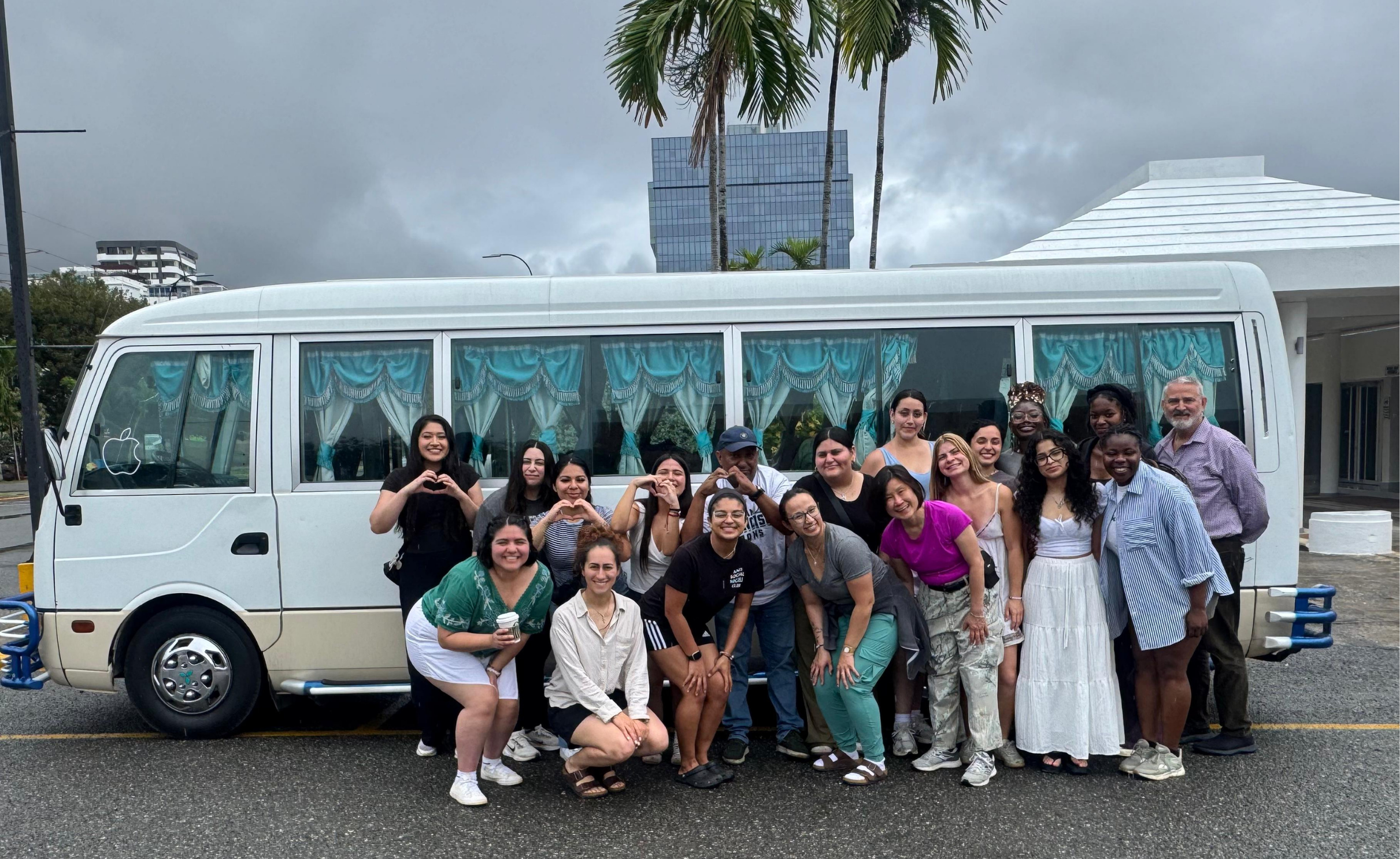 Group of students posing for picture in front of van in the dominican republic