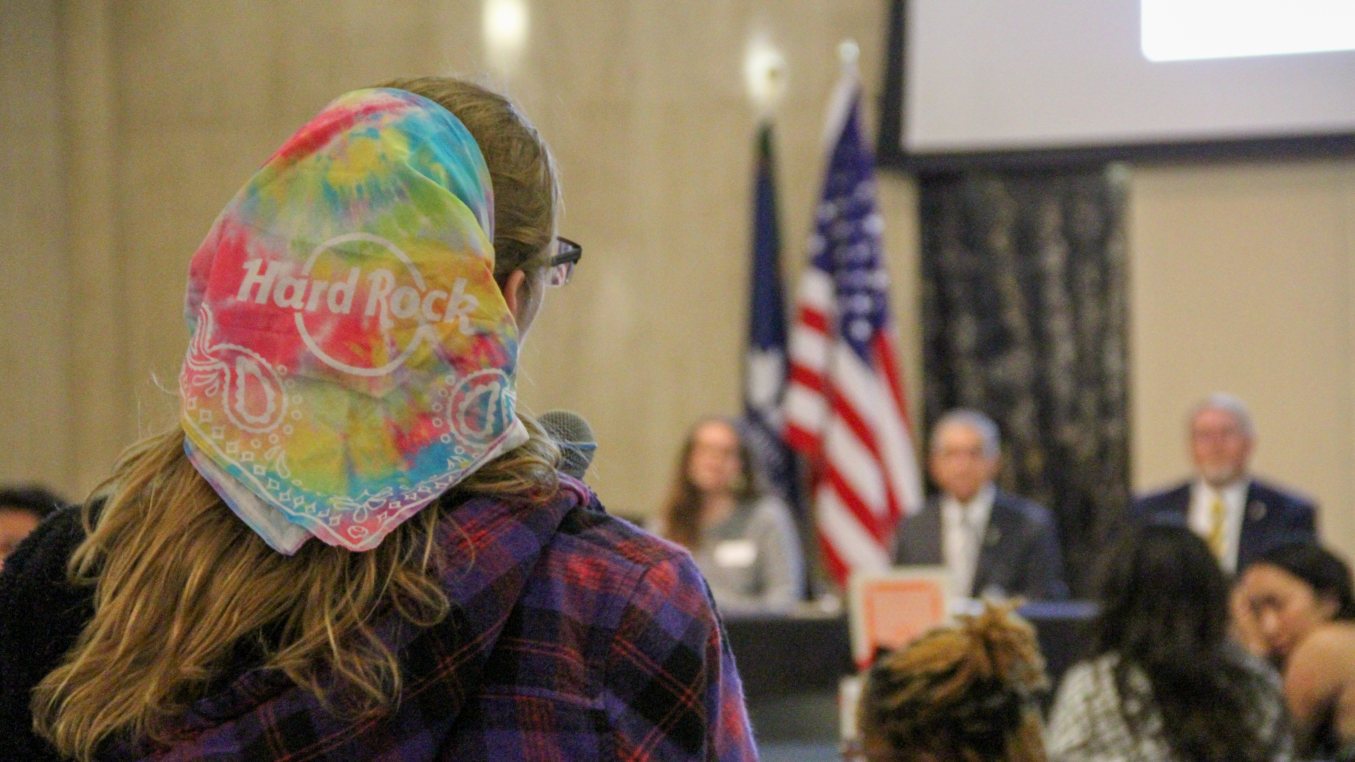 Photo of student speaking out in front of panel of university leaders.