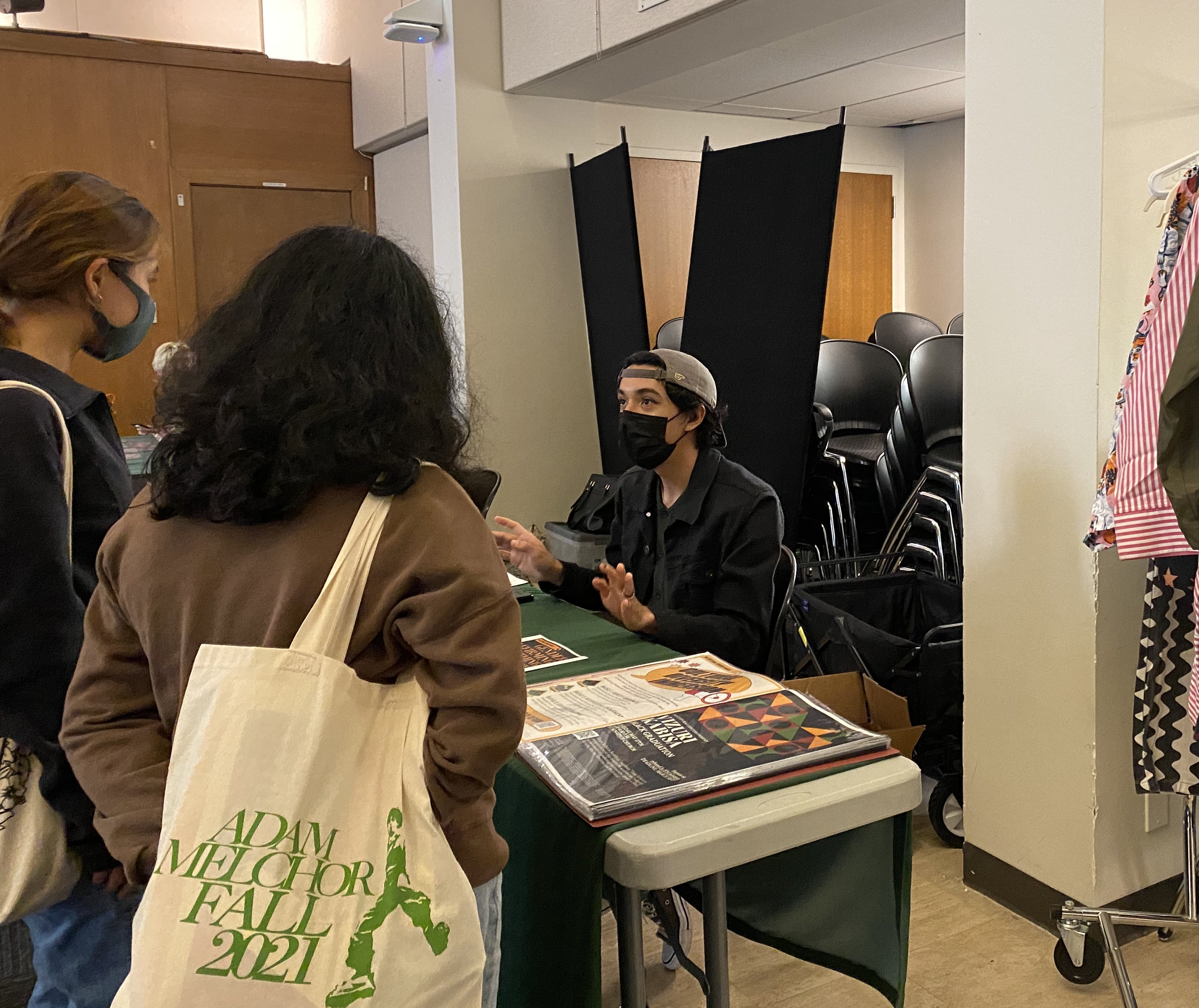 A staff member speaks with students.