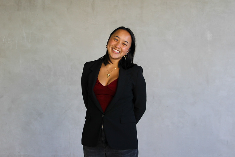 Vice President of Internal Affairs smiling with head tilted to the right, and standing with hands behind back