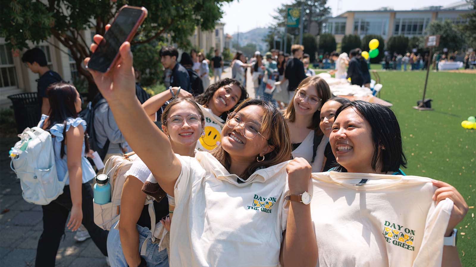 Students holding t-shirts taking a picture