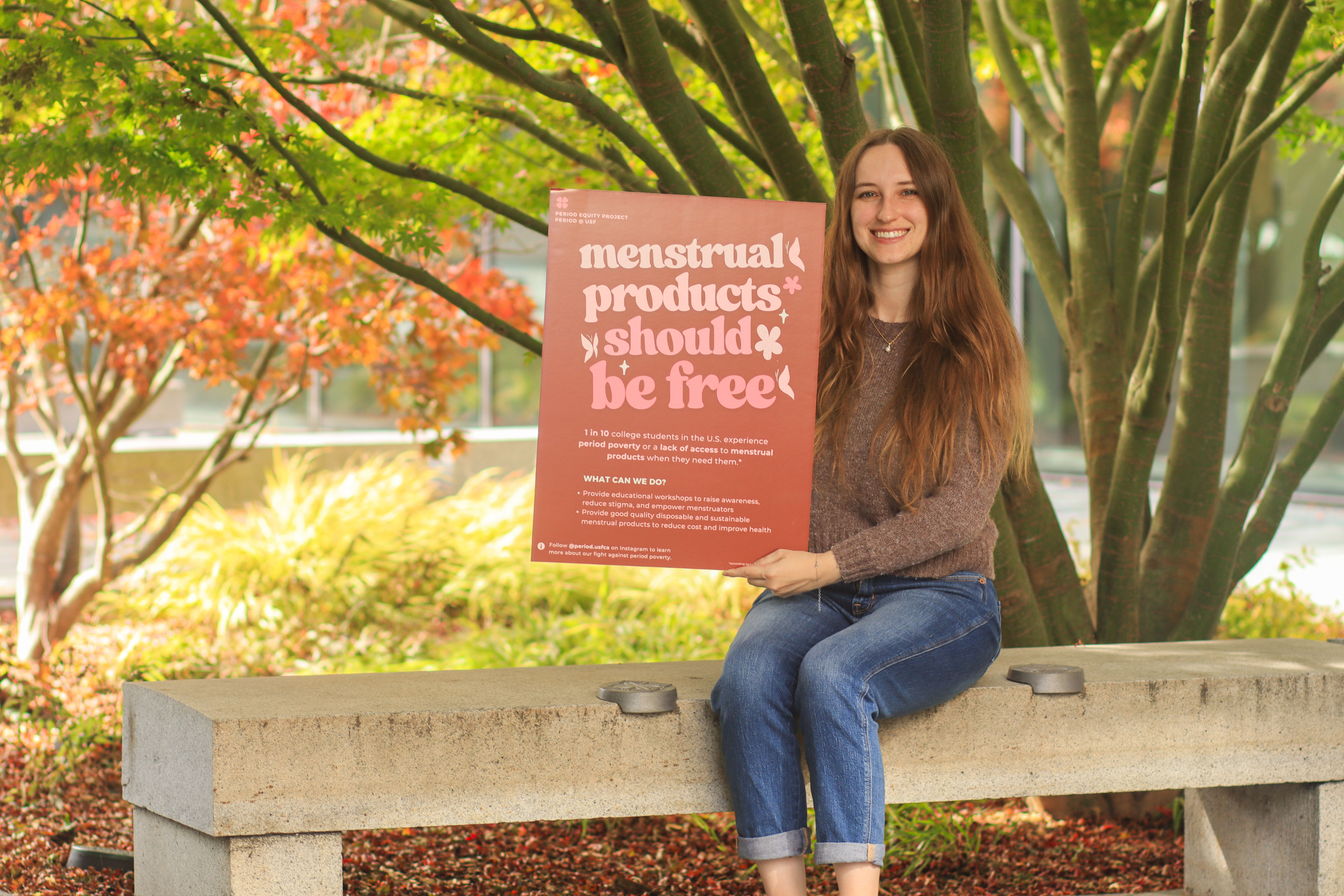 Student holding poster of her Period Equity Project