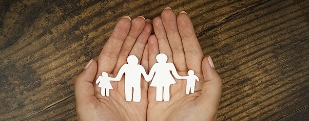 hands holding paper cut out of family