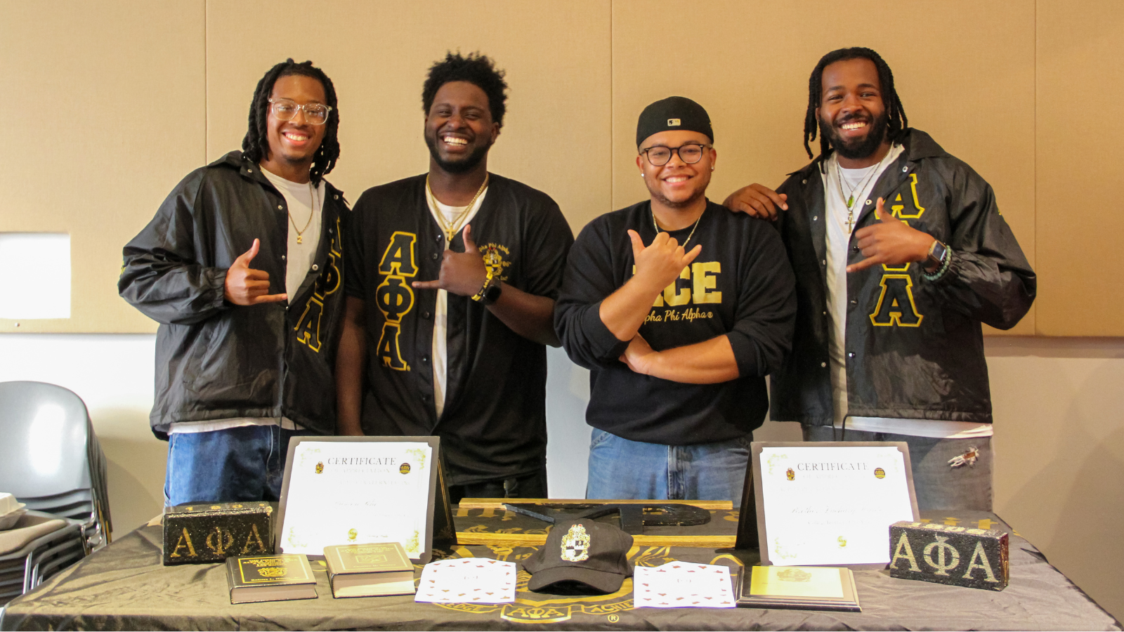 Alpha Phi Alpha Fraternity, Incorporated posing in front of their table.