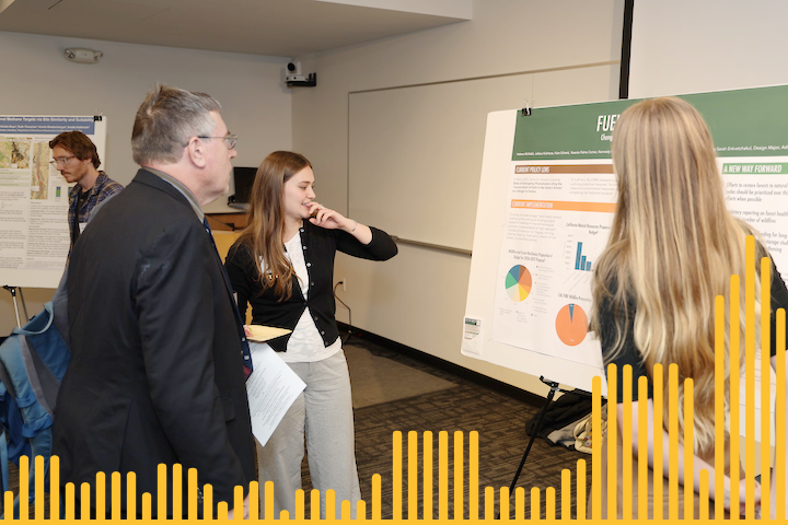 students presenting a research poster to a visitor 