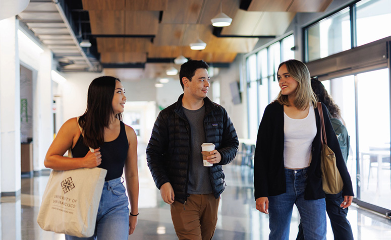 Three USF students walking in cafeteria