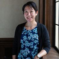 "Professor Leung is an asian woman with short black hair, wearing a floral dress"