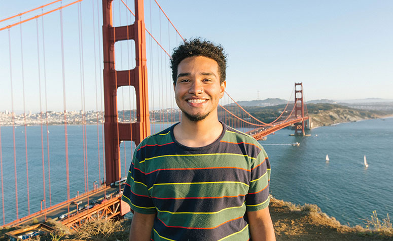 USF student posing in front of the Golden Gate Bridge