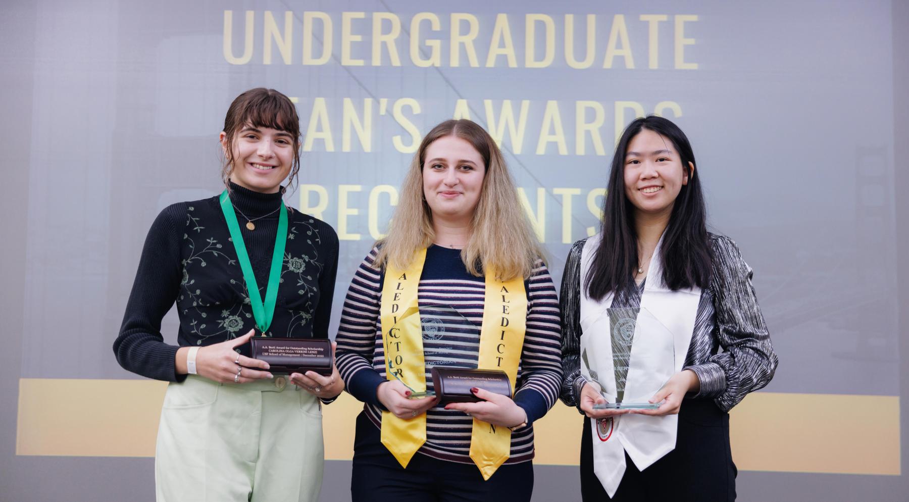 Group of 3 students holding their awards