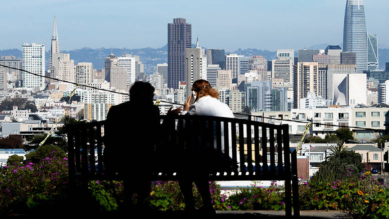 Students working on a bench with SF skyline in background