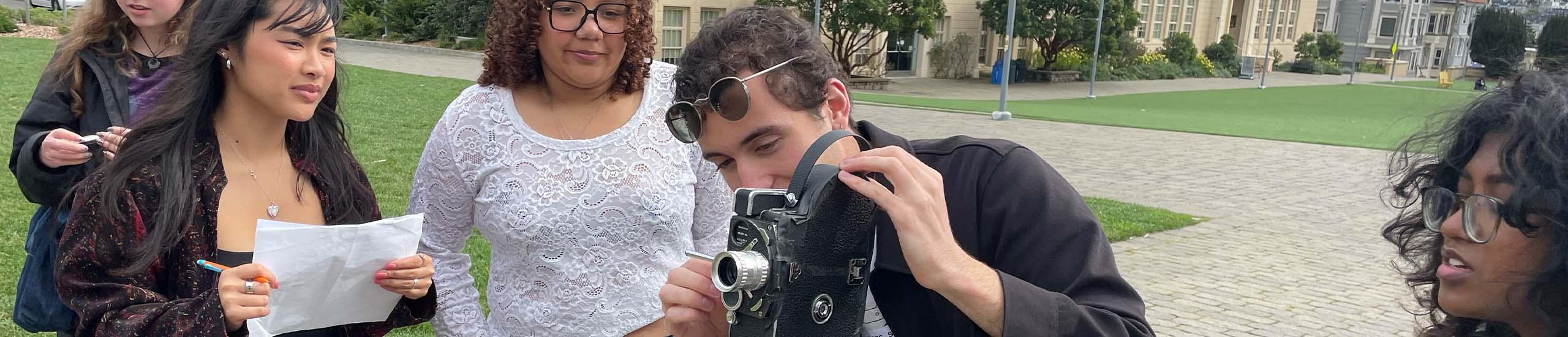 Four students using a film camera