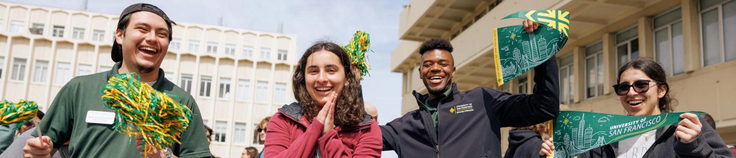 Four students in USF merch smiling and posing