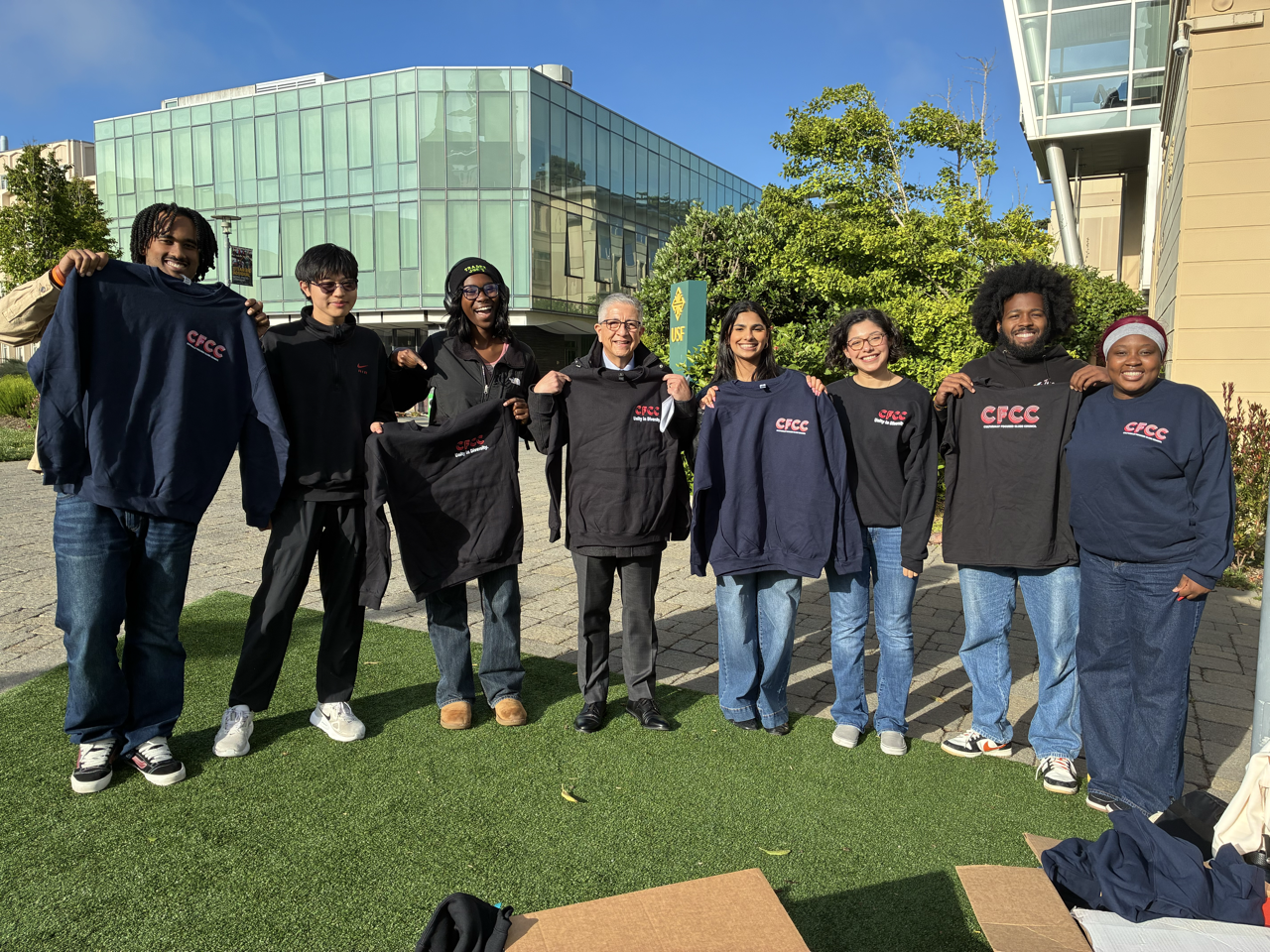 "CFCC members posing with CFCC sweaters they won alongside USF President Aceves"