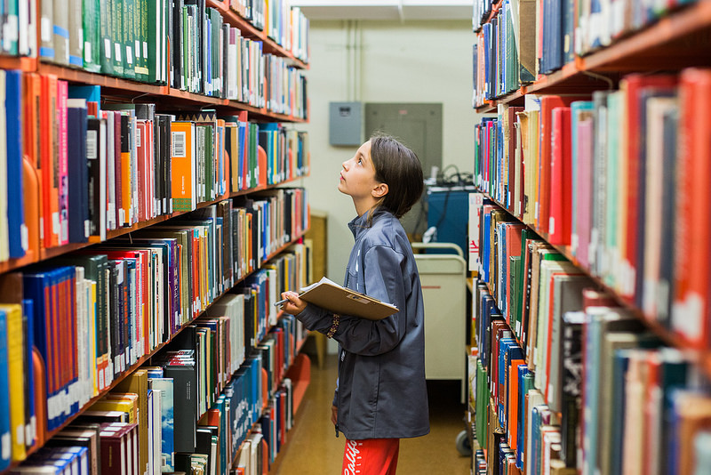 student in library looking at books