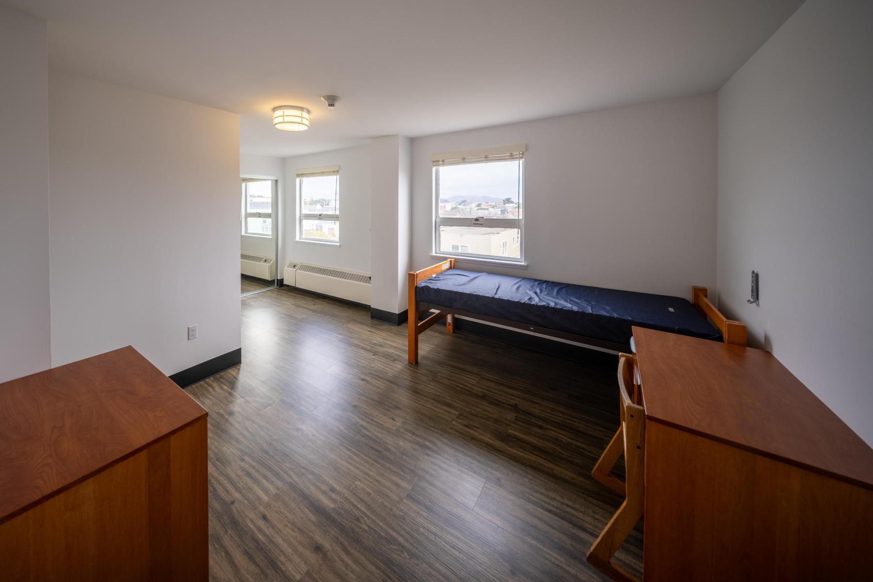 Looking into a Nagle bedroom with a bed, desk, and chair