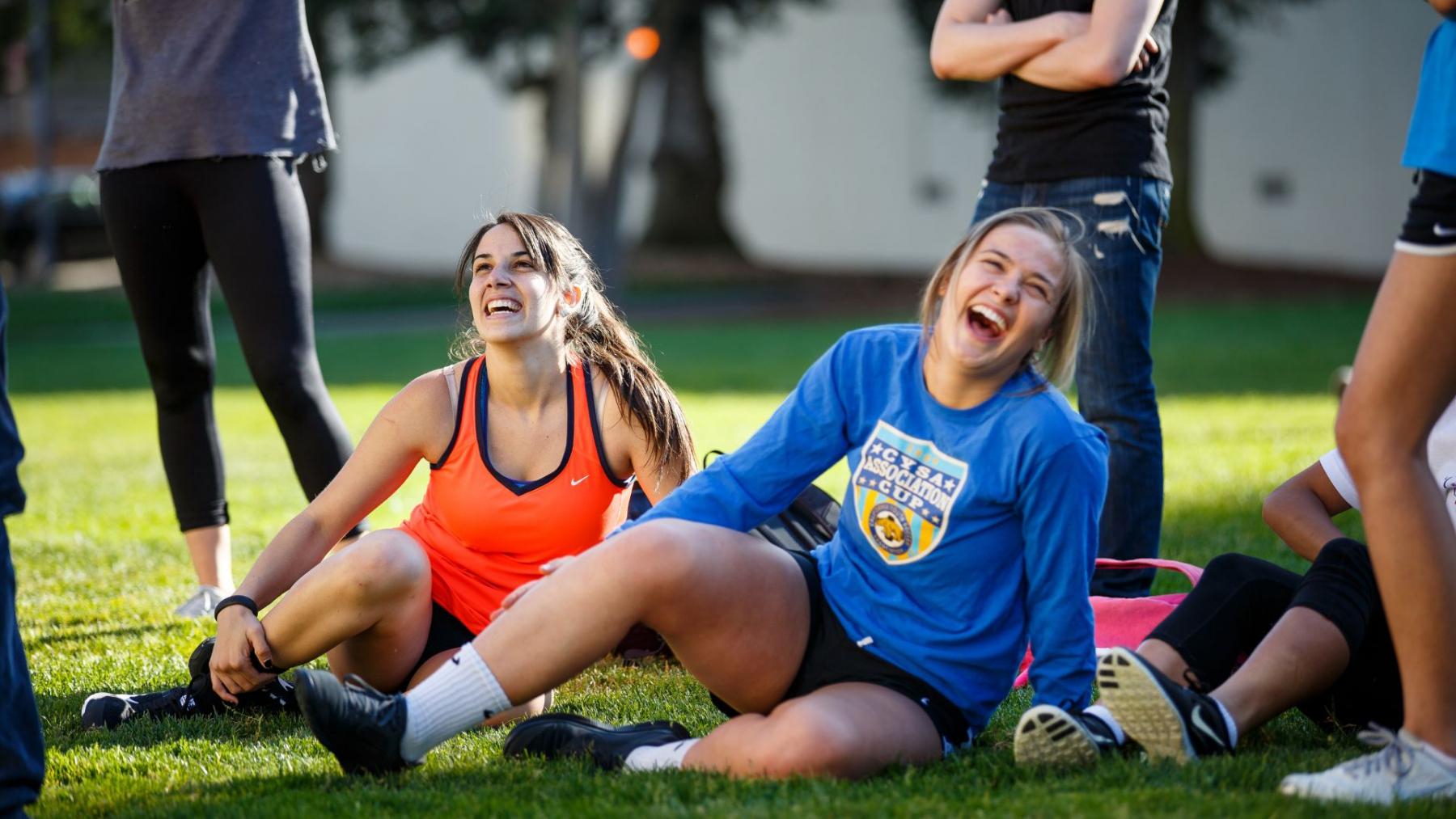 Two students on lawn laughing during competition