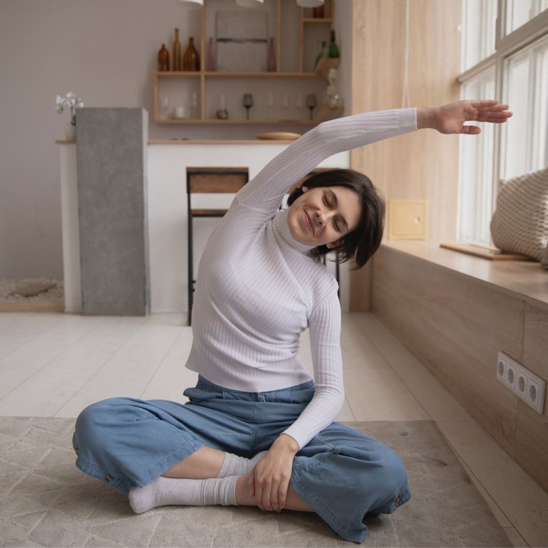 young woman stretching in room