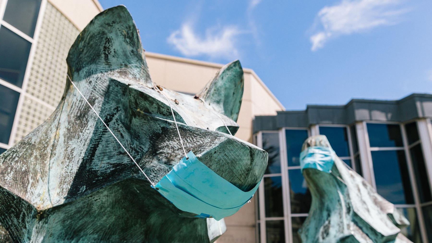 wolf statues wearing masks