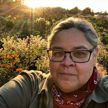 Keynote Speaker Zamora looking at the camera. Field and and sunlight in the background.