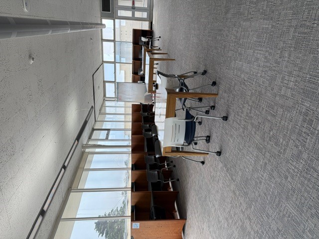"Desks with chairs and a rolling white board"